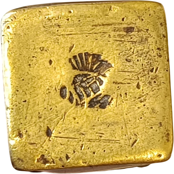 Close view of a metal end cap, with an impressed unidentified stamped mark at its centre and visible surface wear.